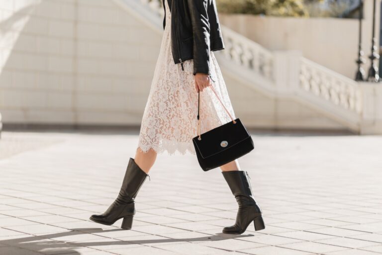 Young Pretty Woman Walking Street Fashionable Outfit Holding Purse Wearing Black Leather Jacket White Lace Dress Spring Autumn Style Warm Sunny Weather Romantic Look 1 768x512